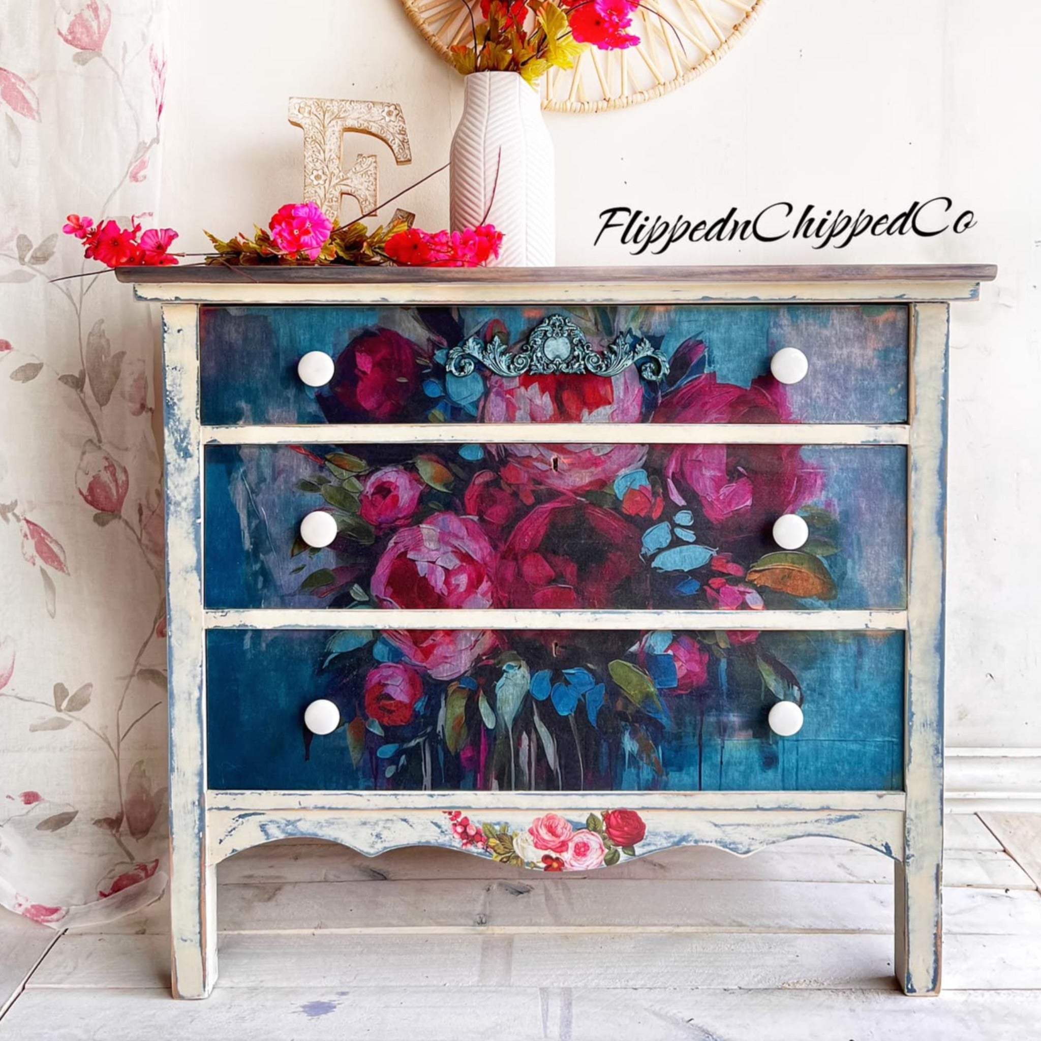 A 3-drawer dresser refurbished by Flipped N Chipped Co. is painted white with blue distressing and features ReDesign with Prima's Burst of Color A1 fiber paper on the drawers.