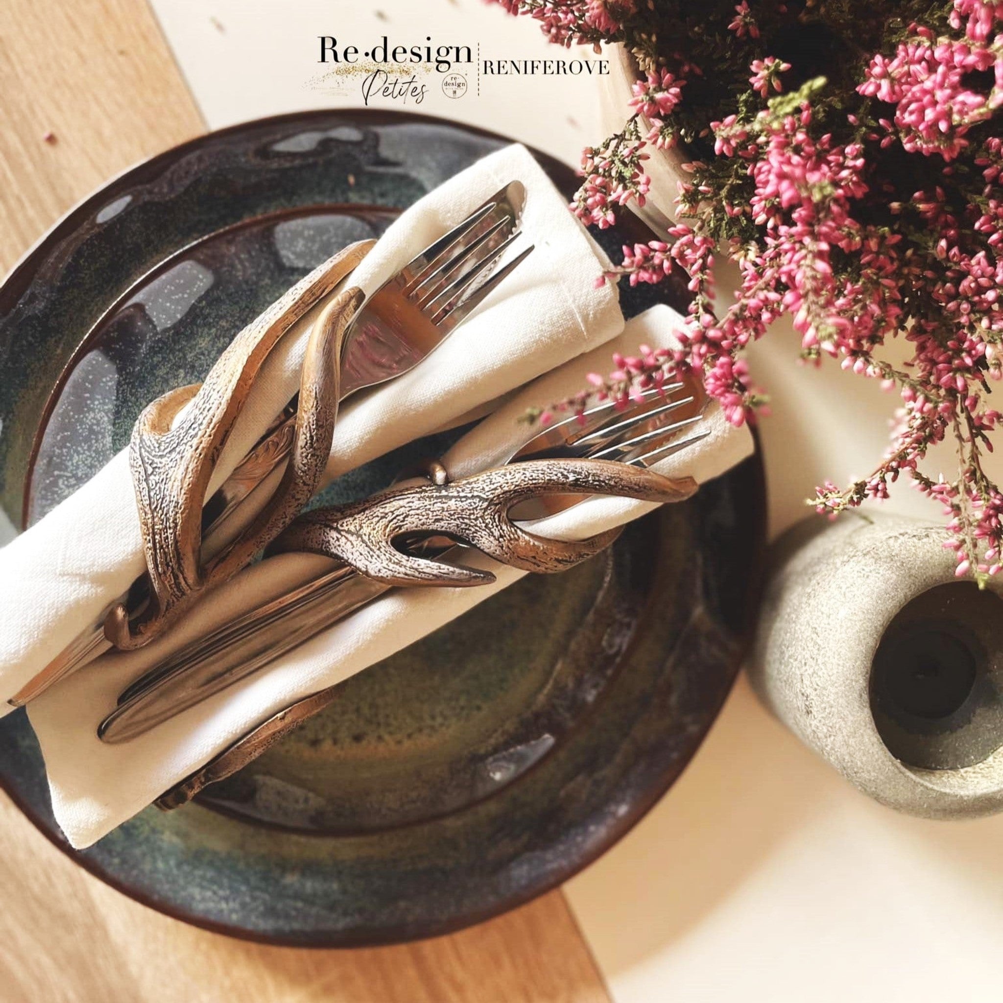 Napkin holders created by Reniferove using the antlers from ReDesign with Prima's Loggers Lodge silicone moulds are featured holding a fork, butter knife, and napkin on a dark ceramic plate.