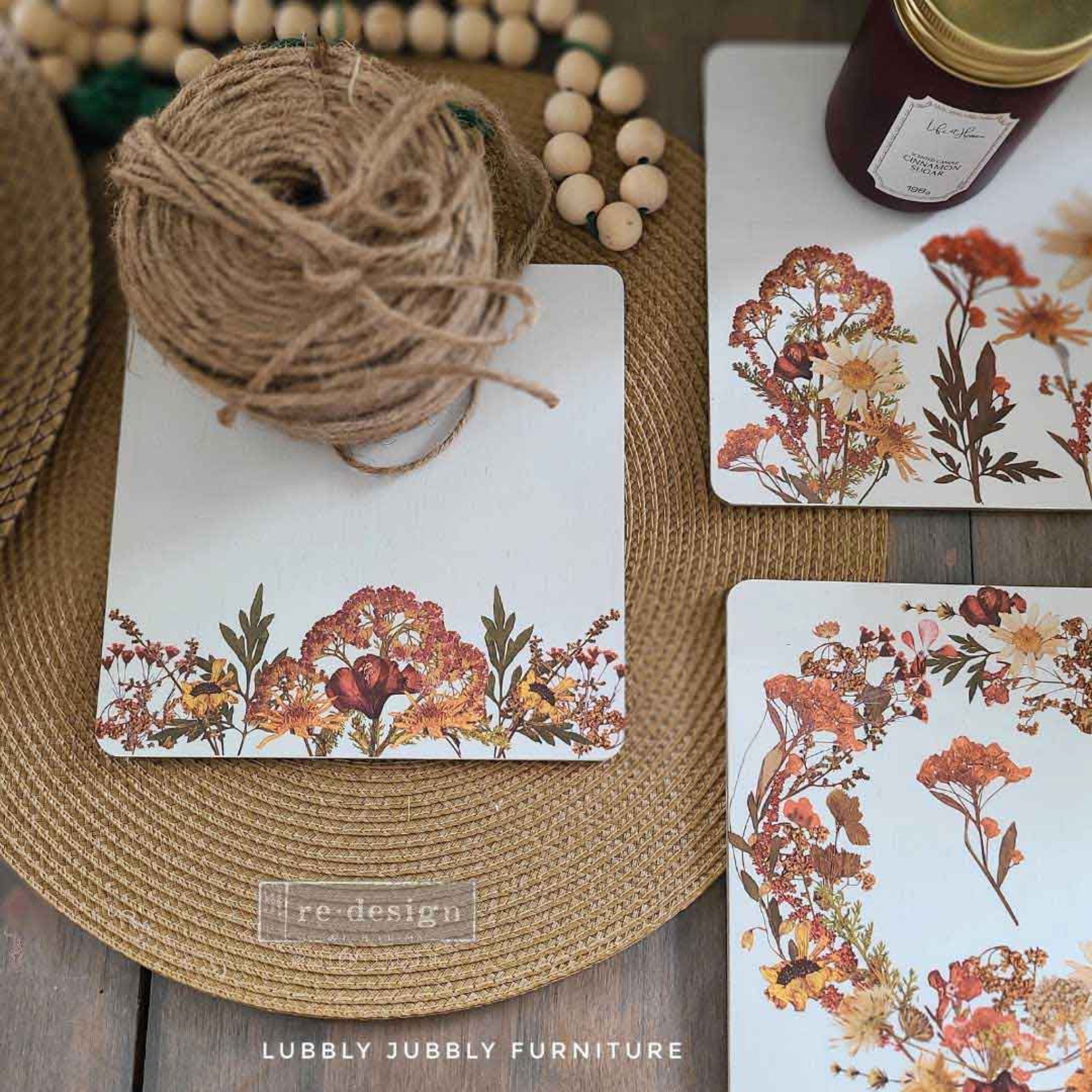 Three white square coasters created by Lubbly Jubbly Furniture feature ReDesign with Prima's Dried Wildflowers small transfers on them.