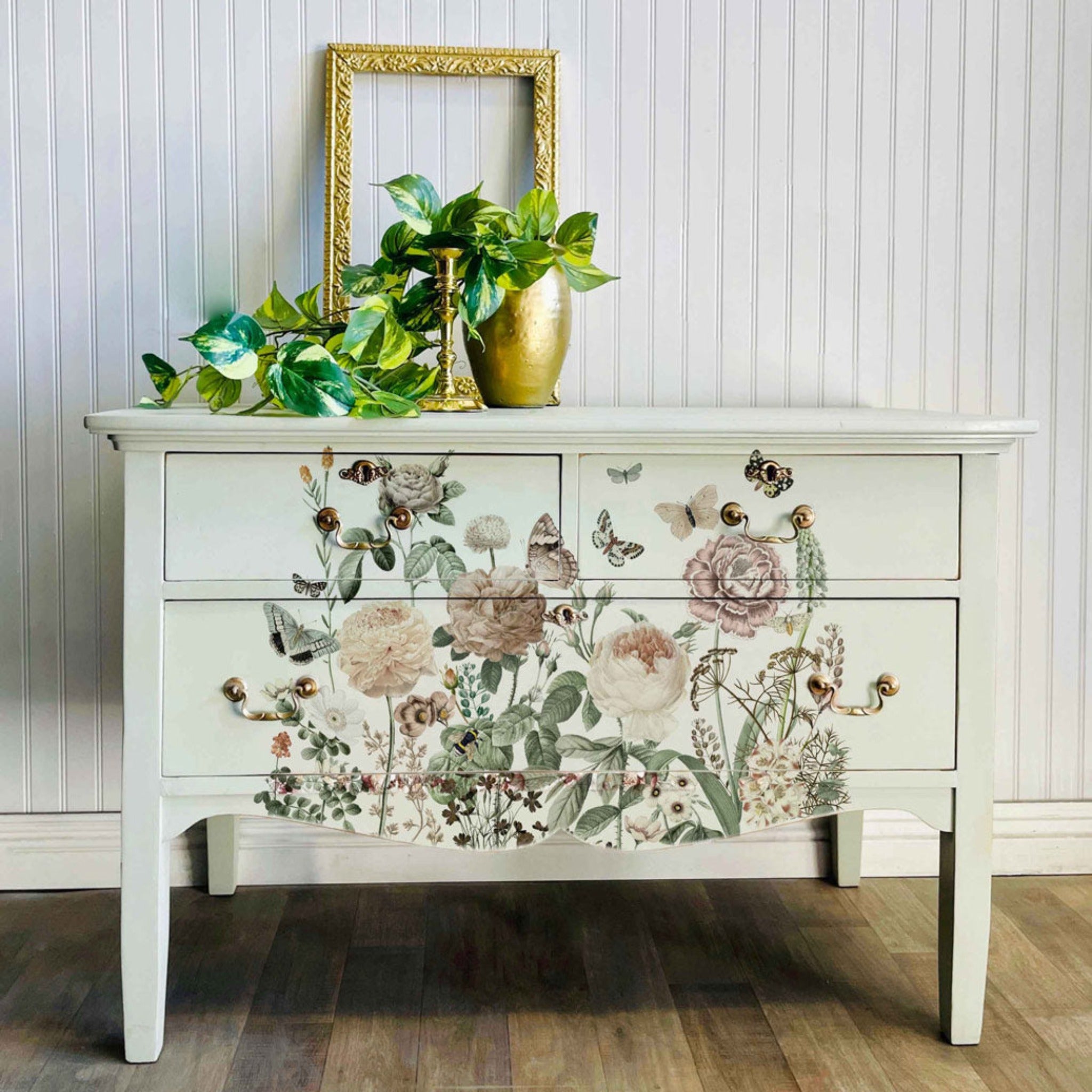 A vintage 3-drawer dresser with long legs is painted off-white and features ReDesign with Prima's All the Flowers transfer on the front.