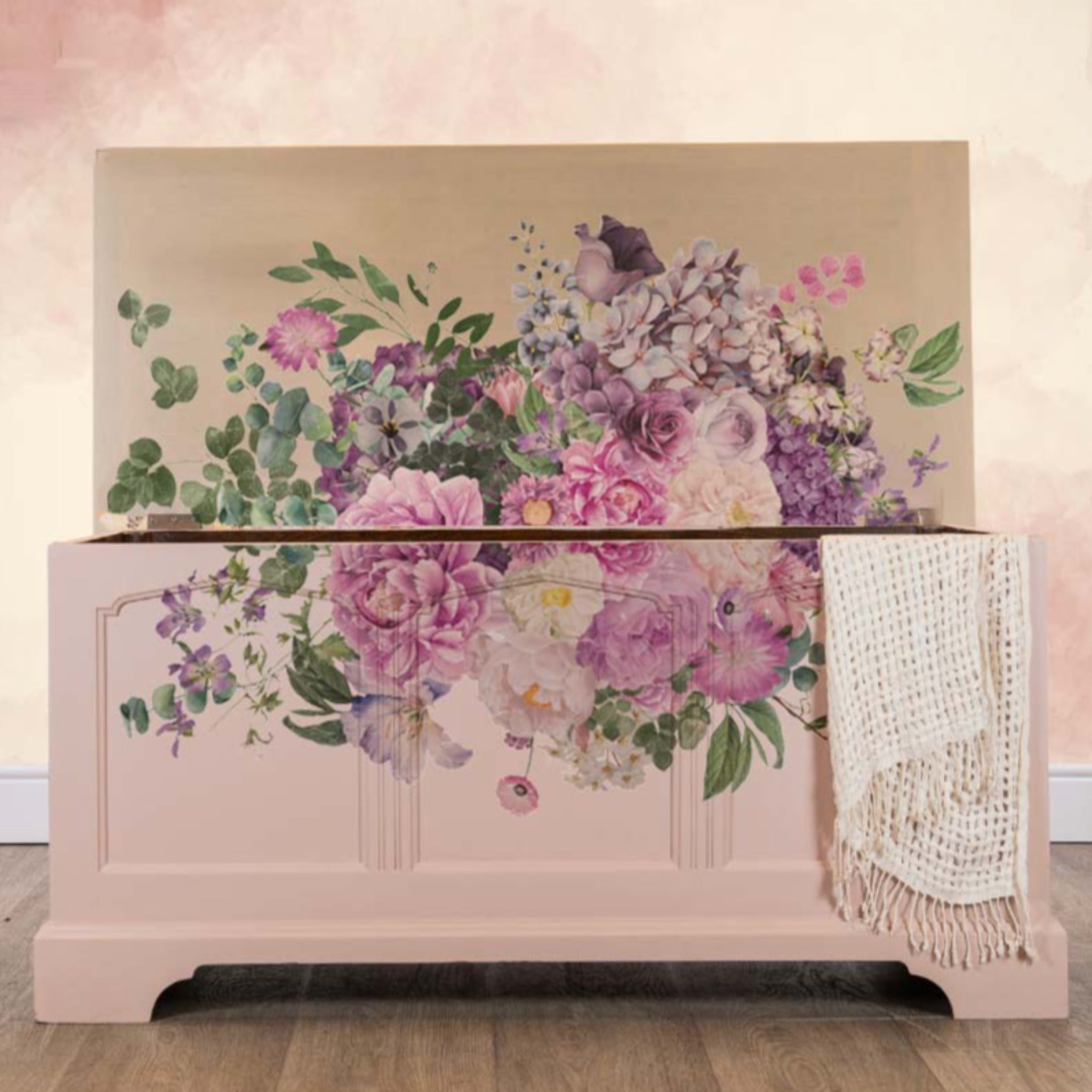A wood storage chest with the lid open is painted light tan and features ReDesign with Prima's Kacha Morning Purple transfer on the front and inside the lid. When the lid is open it creates a full image of the transfer.