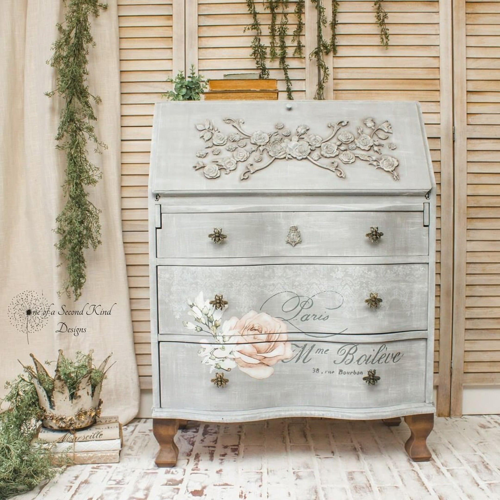 A vintage secretary's desk refurbished by One of a Second Kind Designs is painted light grey and features the Chatellerault transfer on its drawers.
