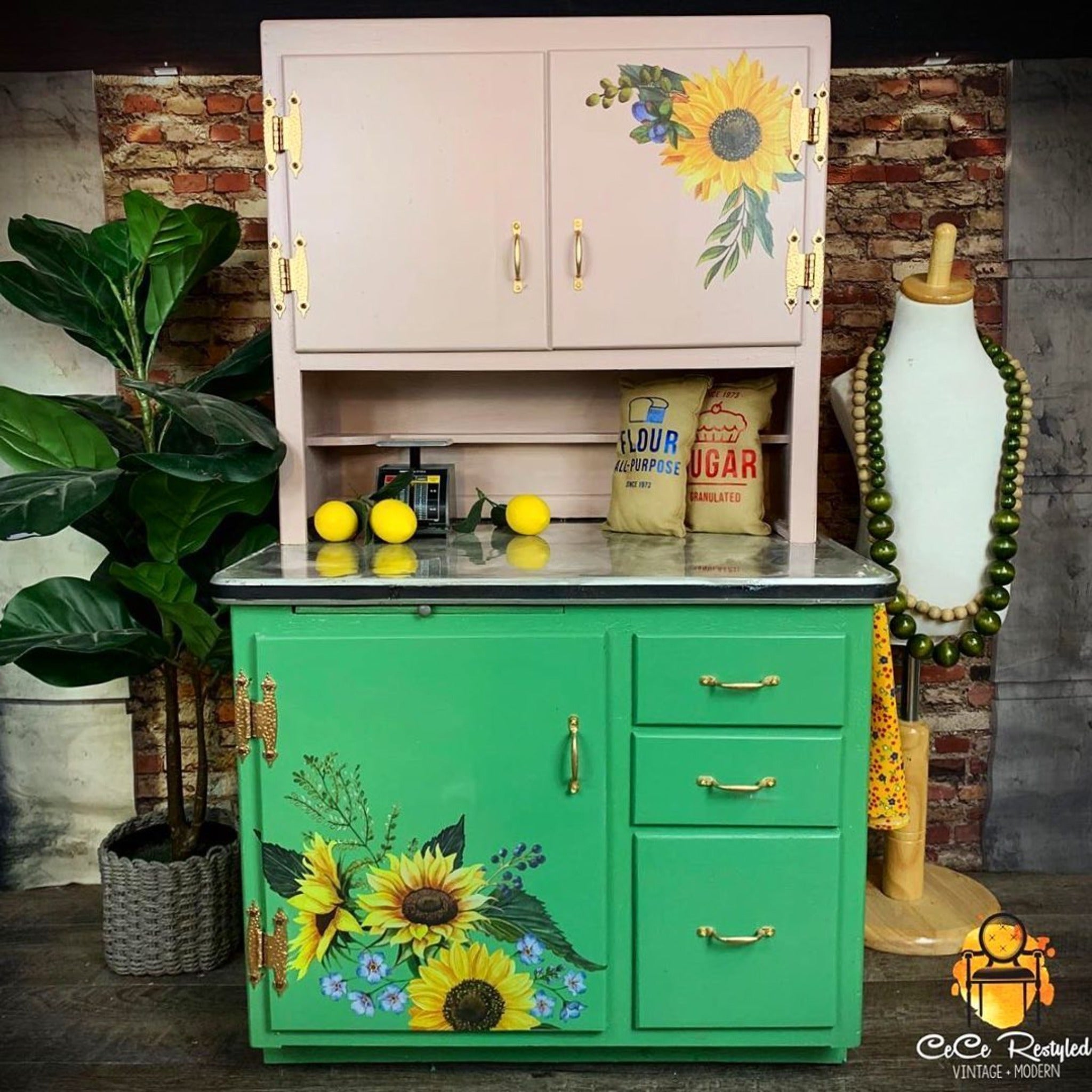 A vintage child-size Hoosier Cabinet refurbished by CeCe ReStyled is painted beige on the hutch top and green on the bottom cabinet and features ReDesign with Prima's Sunflower Fields transfer on the top right hutch and bottom left cabinet.