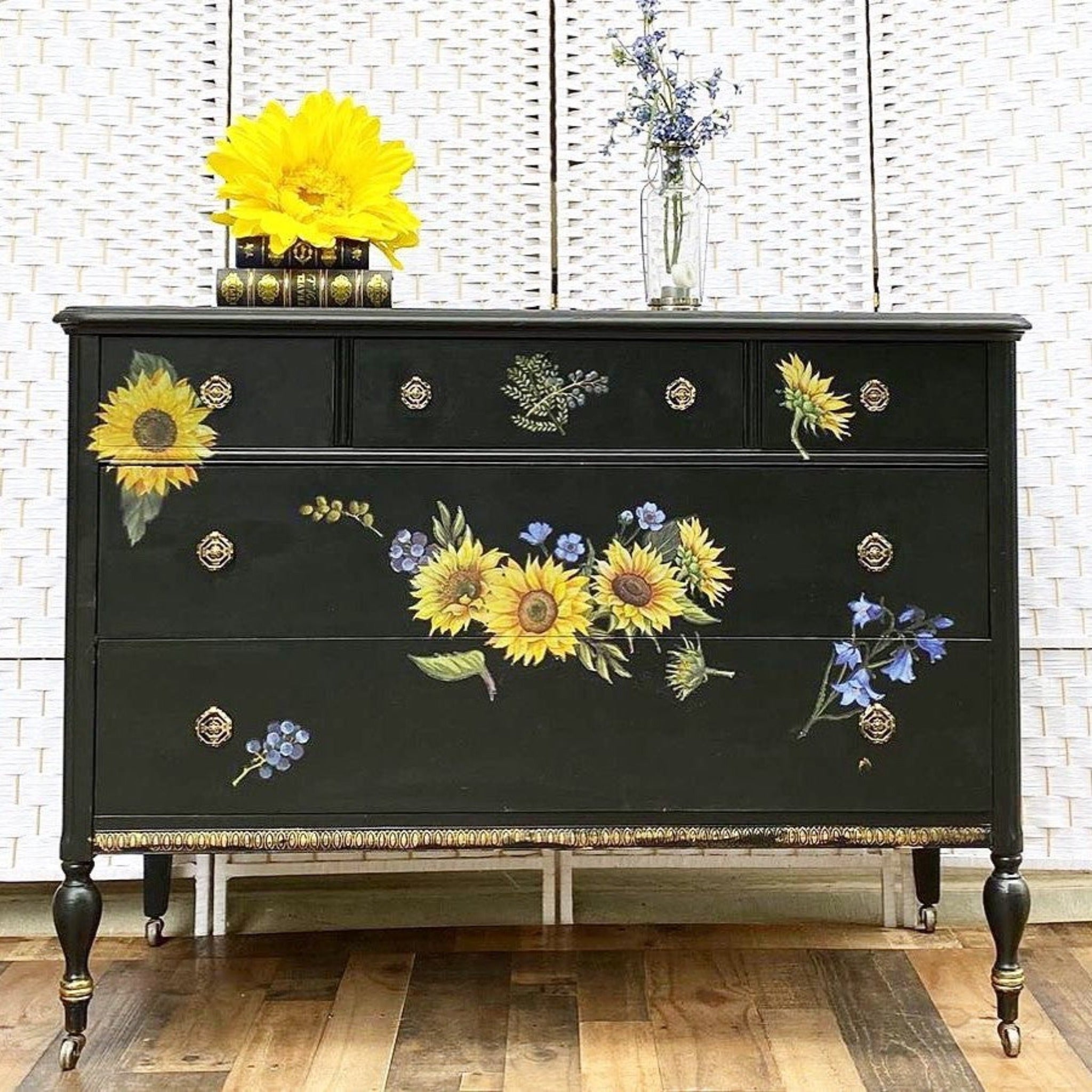 A vintage dresser is painted black and features ReDesign with Prima's Sunflower Fields transfer on its drawers.