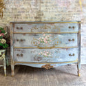 A vintage 3 drawer dresser refurbished by Laura Designs Shop is painted a mottled grey with gold accents and features ReDesign with Prima's Kacha Les Roses transfer down the center of the dresser.