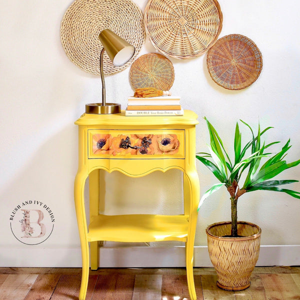 A vintage 1-drawer nightstand refurbished by Blush & Ivy Design is painted bright yellow and features ReDesign with Prima's Poppy Gardens transfer on the drawer.