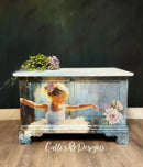 Decorative chest with a painted design of a young girl and flowers on a dark background.