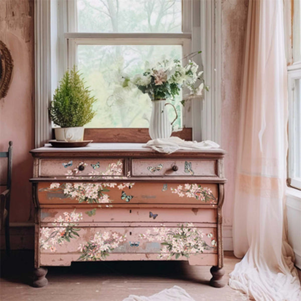 A vintage dresser is painted a blend of pinks and features the Blossom Botanica transfer on its drawers.