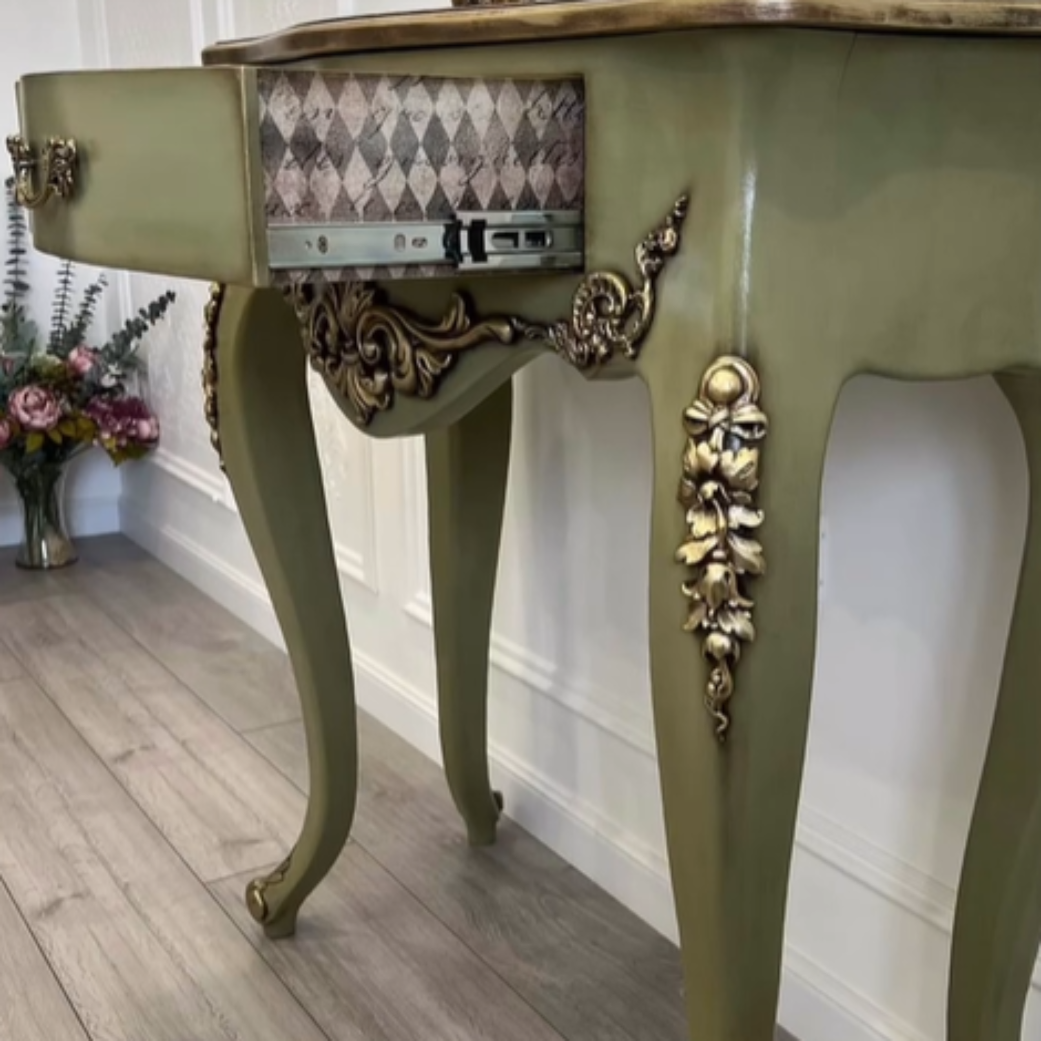 A vintage small desk refurbished by @provans_volga on Instagram is painted olive green and features Decoupage Queen's Neutral Harlequin rice paper on the sides of its 1 small drawer. 