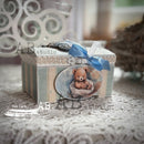 Decorative box with a teddy bear illustration and blue ribbon on a textured surface.