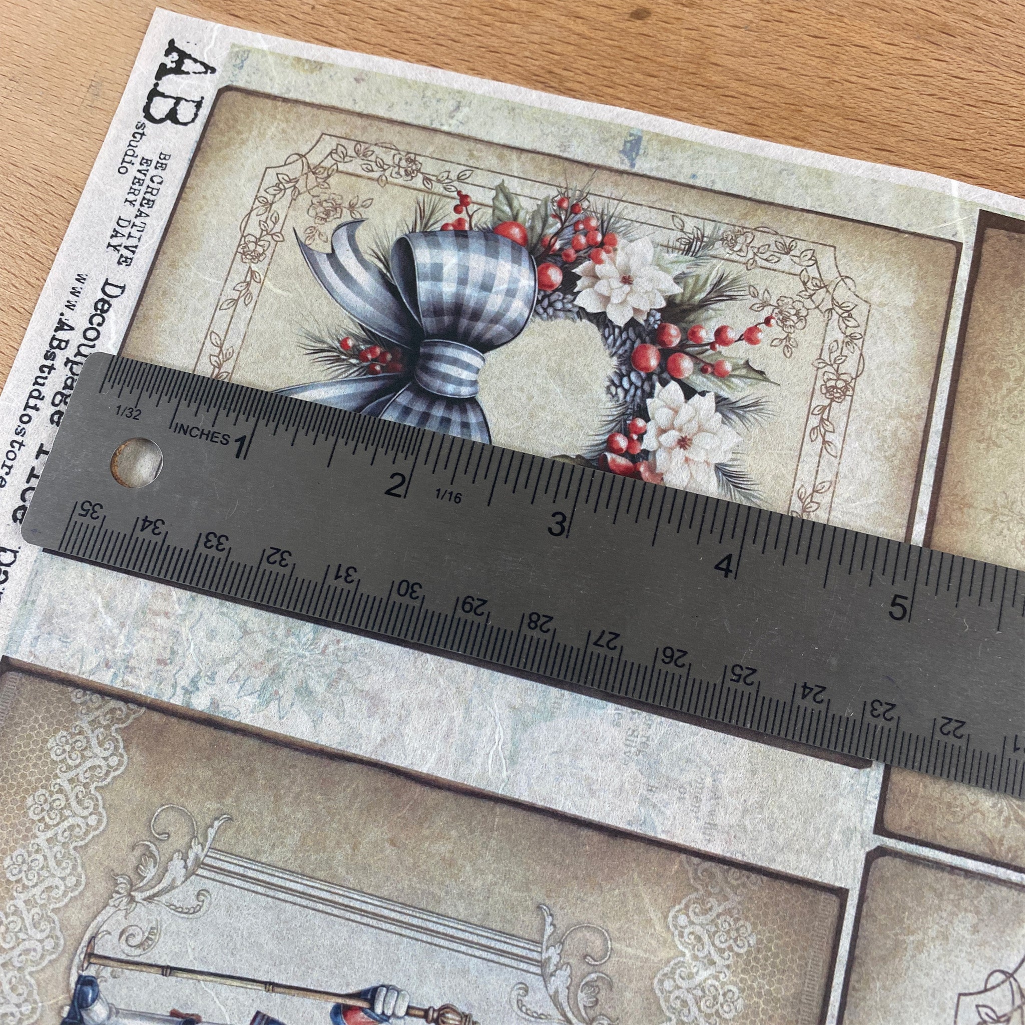 Decorative paper with floral and bow design on a wooden surface, ruler for scale.