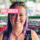 Maria Del Mar Clark, founder and CEO of Maika Daughters, smiling with purple hair and pendant necklace—creative entrepreneur behind upcycling and DIY furniture supplies.