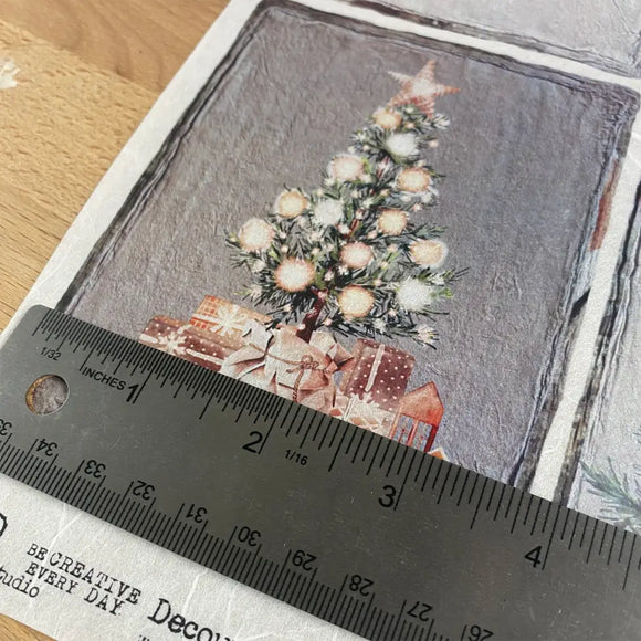 Christmas tree and presents on a textured paper with a ruler for scale.