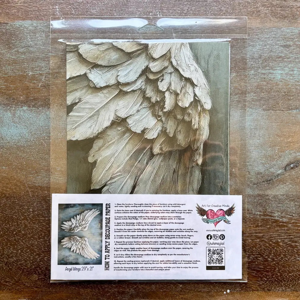 a package of Whimsykel's Angel Wings tissue paper is against a wood background.