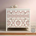 A white dresser features ReDesign with Prima's Annie Sloan's Flower Garland transfer on the drawers.