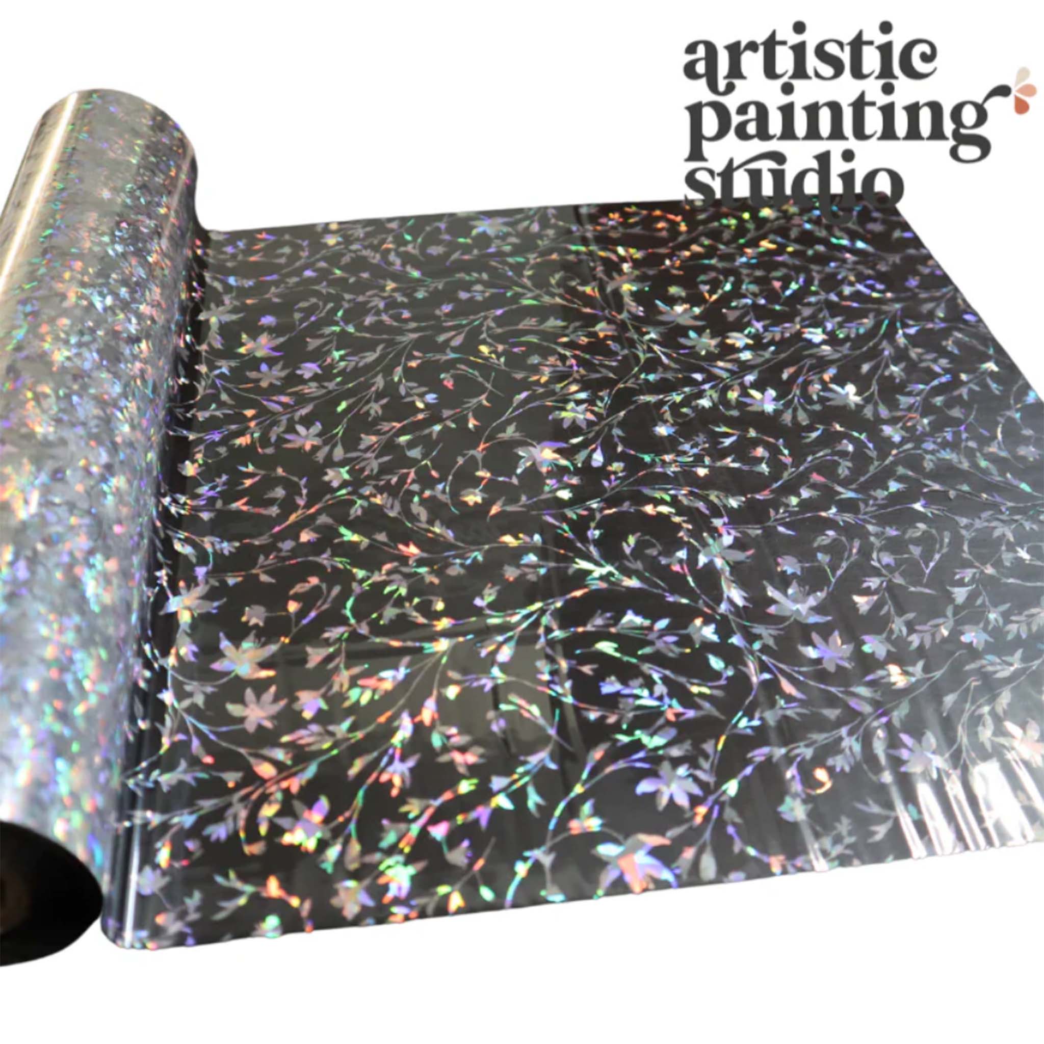 A roll of a silver holographic foil transfer that features dainty leafy vines is against a white background.