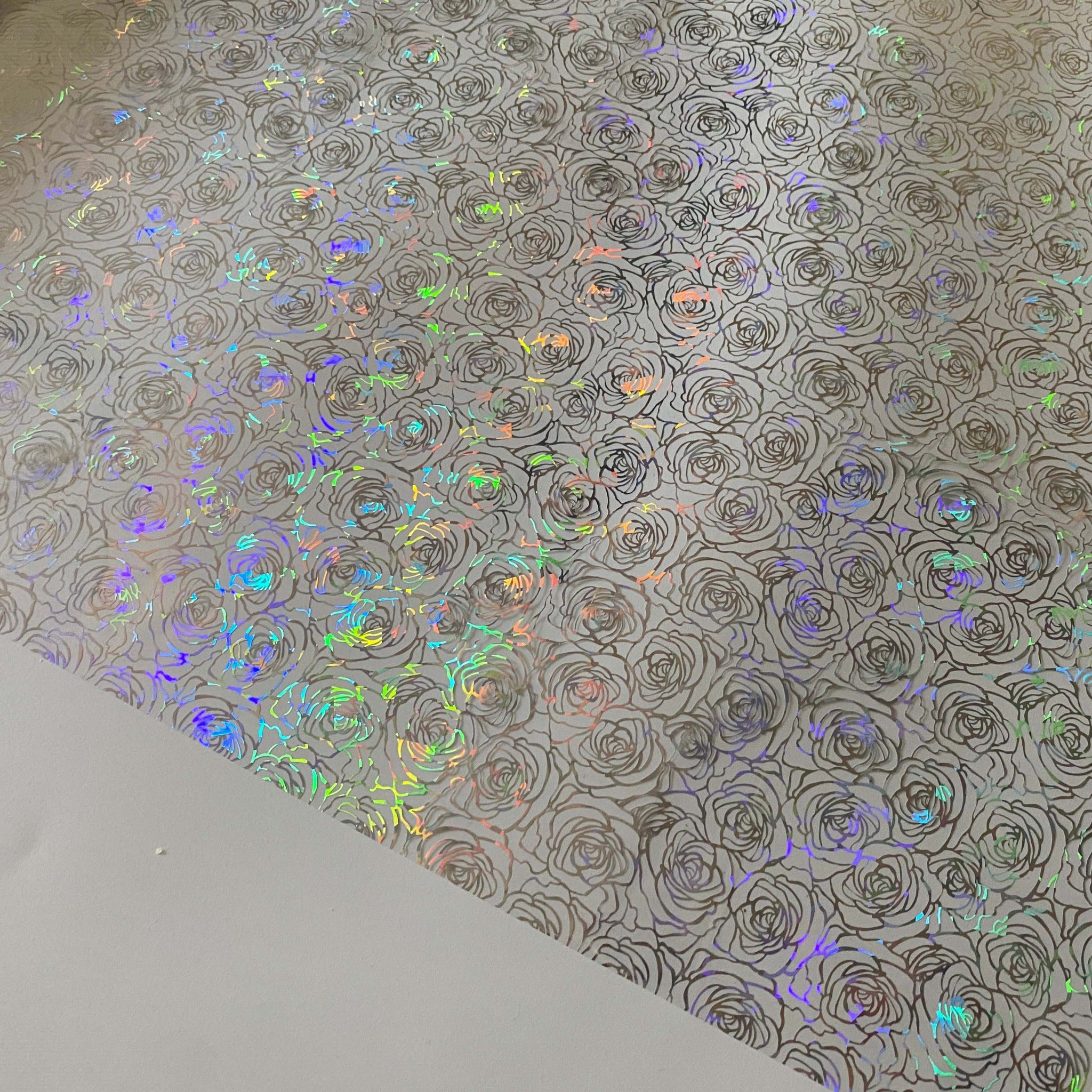 A close-up of Artistic Painting Studio's Monroe Hologram Foil Transfer is shown against a white background and shows the rainbow holographic effect on the rose pattern.