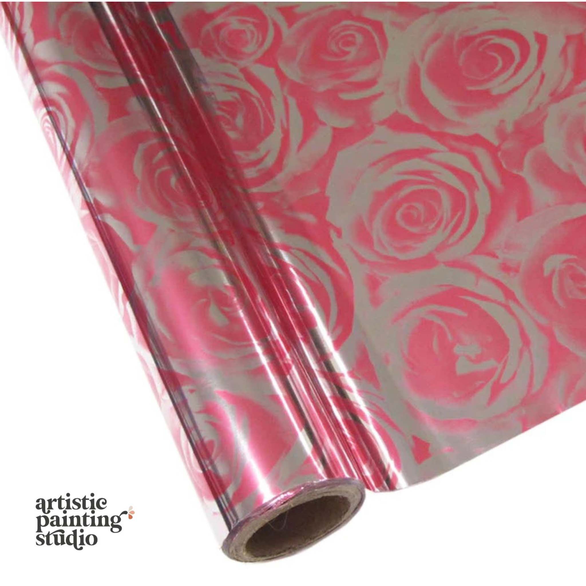 A roll of a silver metallic transfer foil that features large pink rose blooms is against a white background.