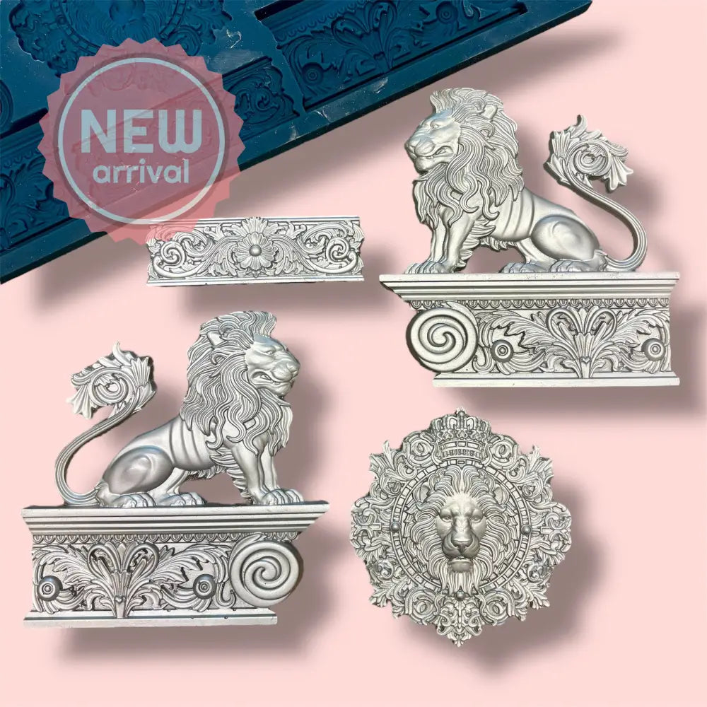A blue silicone mold and silver colored castings featuring two lion statues facing opposite directions, a lion's head in a frame, and a low baroque border are against a light pink background.