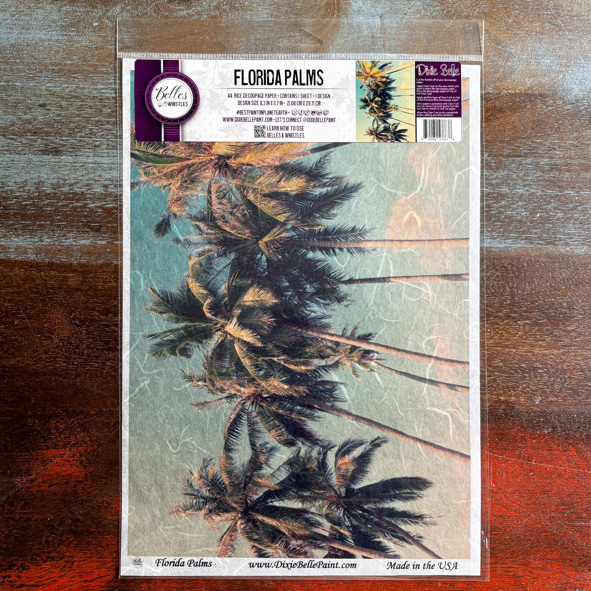 A package of Belles & Whistles' Florida Palms A4 rice paper is against a dark wood background.