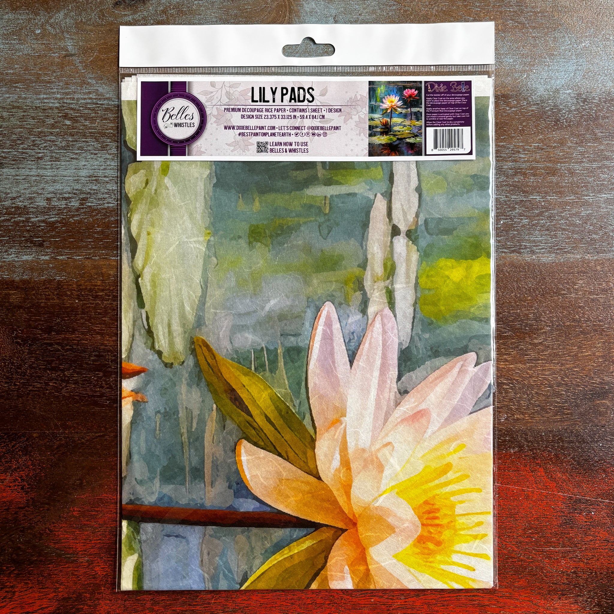 A package of Belles & Whistles' Lily Pads A1 rice paper is against a dark wood background.