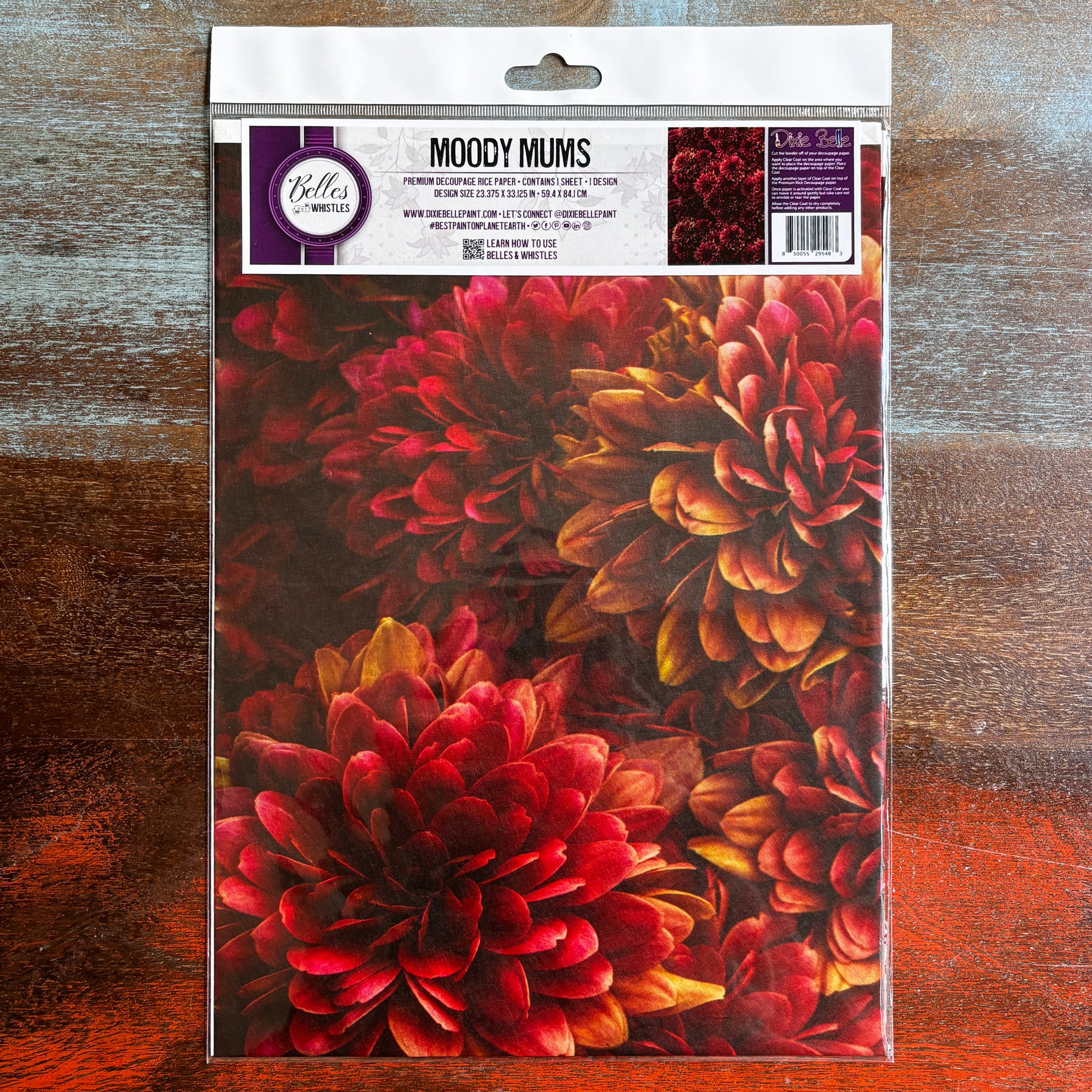 A package of Belles & Whistles' Moody Mums A1 rice paper is against a dark wood background.