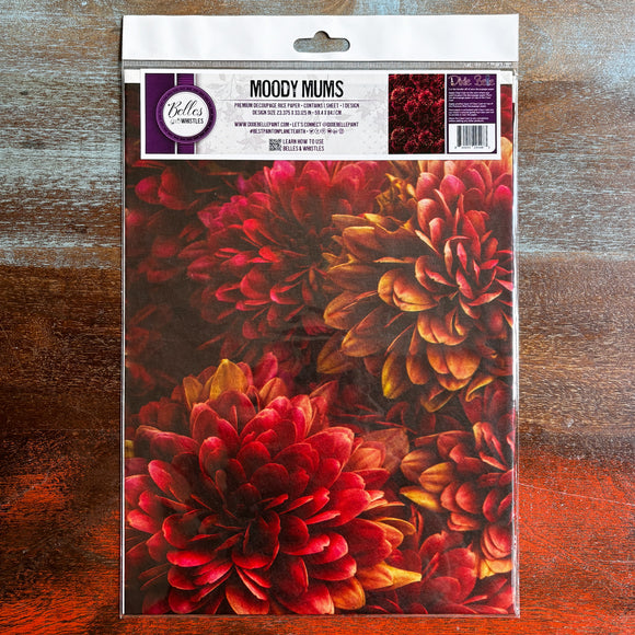 A package of Belles & Whistles' Moody Mums A1 rice paper is against a dark wood background.