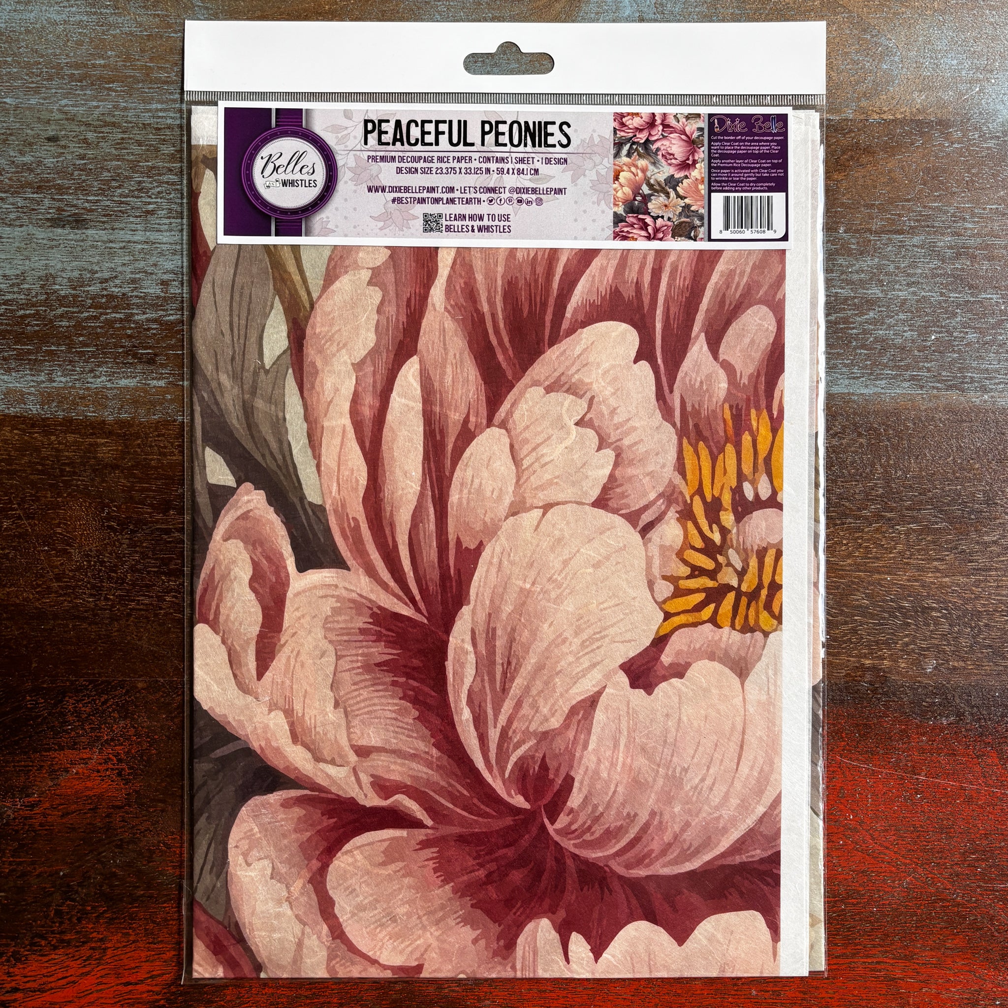 A package of Belles & Whistles' Peaceful Peonies A1 rice paper is against a dark wood background.