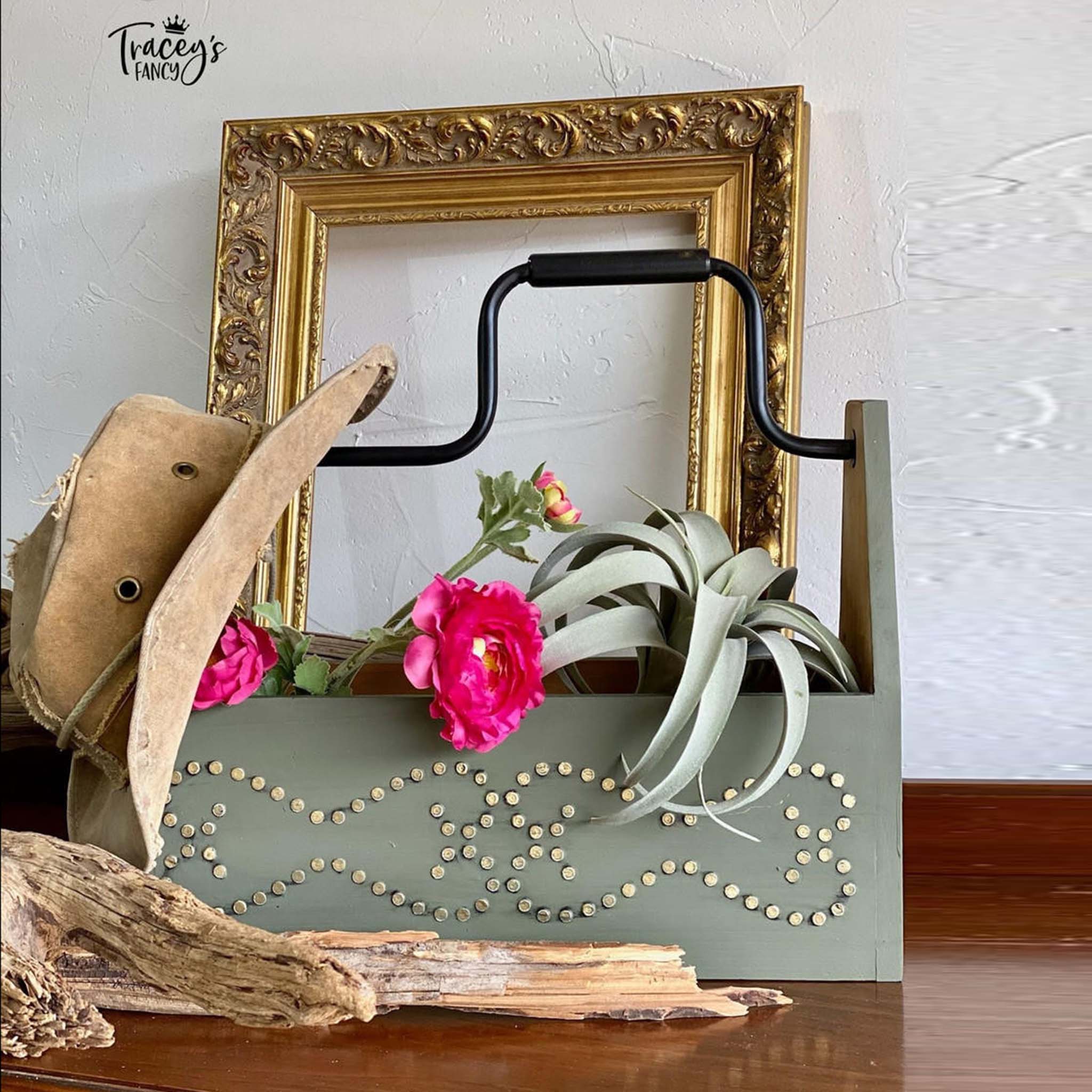 A vintage wood toolbox refurbished by Tracey's Fancy is painted light sage green and features Belles & Whistles Nailhead Trim mylar stencil design as a raised design painted to replicate actual nailheads.