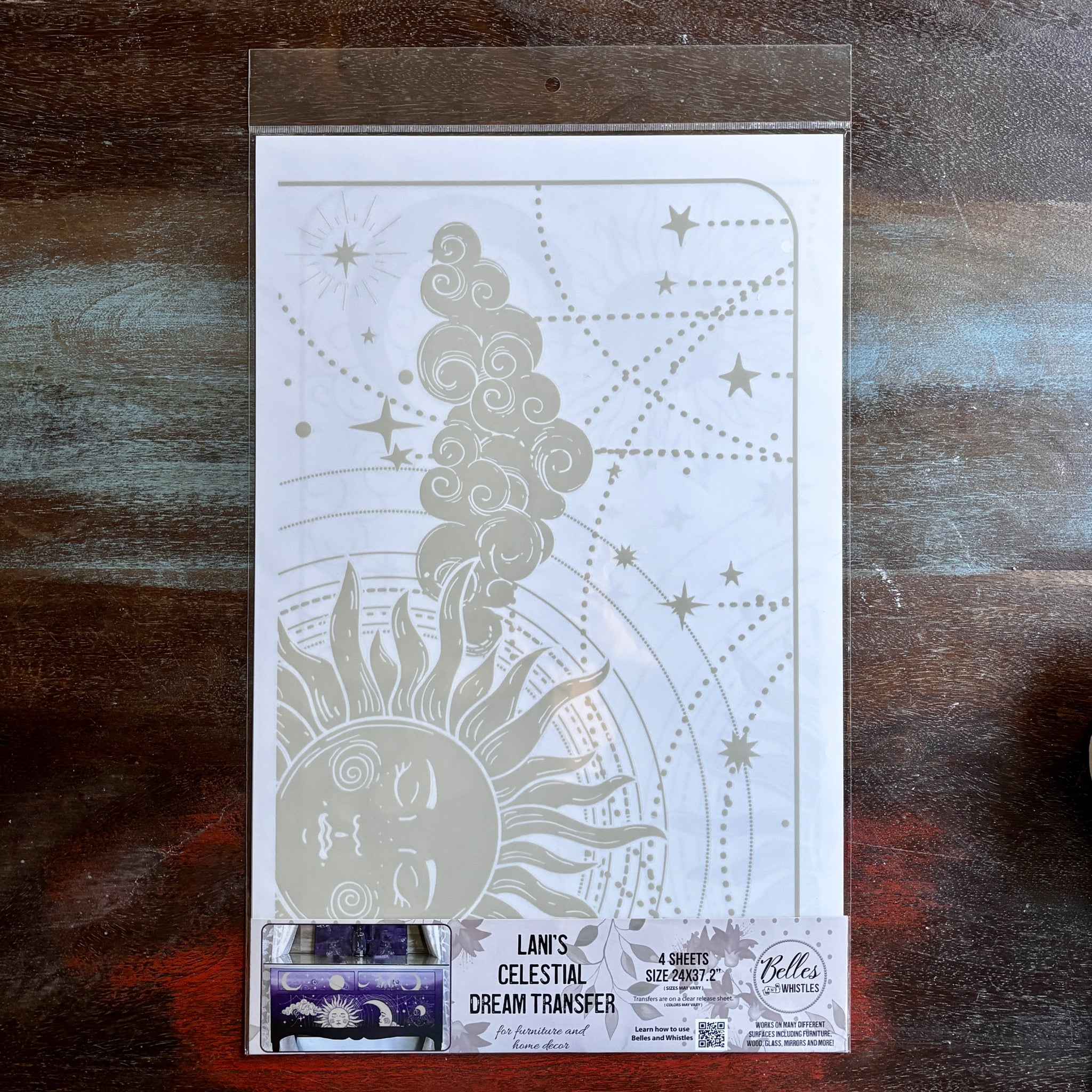 A package of Belles & Whistles' Lani's Celestial Dream rub-on transfer is against a dark wood background.