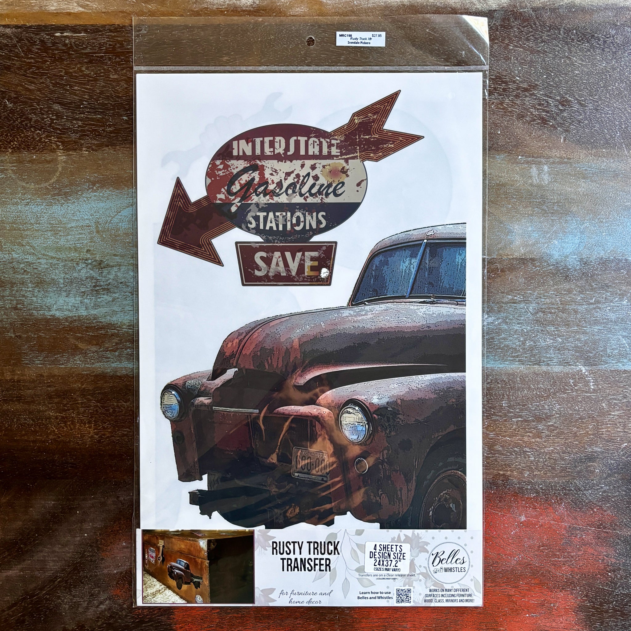 A package of Belles & Whistles' Rusty Truck rub-on transfer is against a dark wood background.