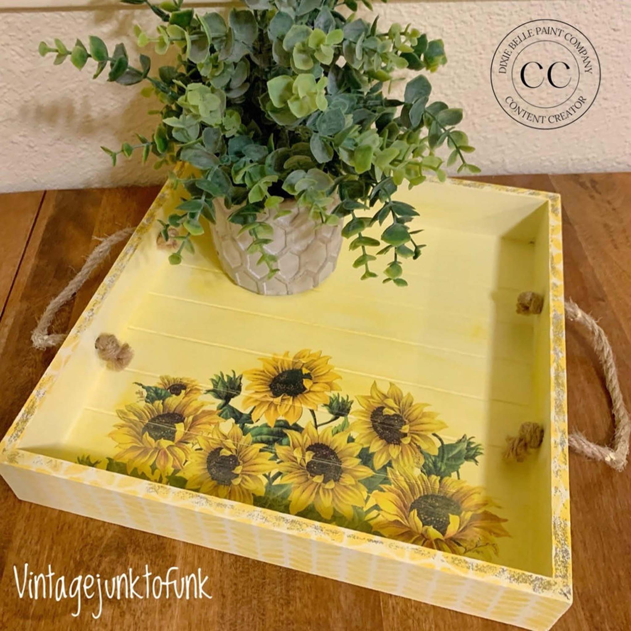 A wood tray with rope handles refurbished by Vintage Junk to Funk is painted yellow and features Belles & Whistles Cozy Sweater mylar stencil in white on its outer sides. 