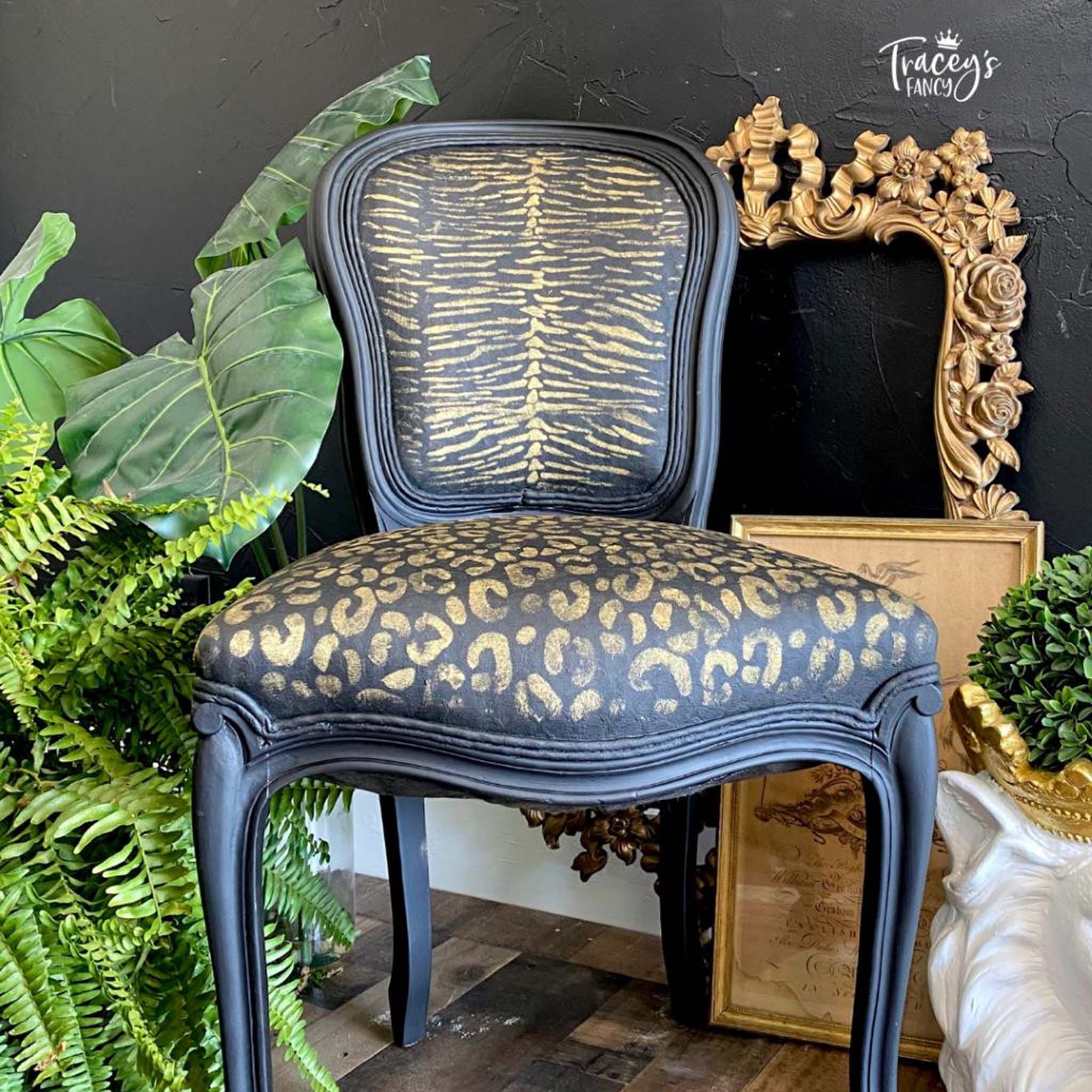 A vintage chair refurbished by Tracy's Fancy is painted black and features Belles & Whistles Safari mylar stencil in amber on the seat and seat back.