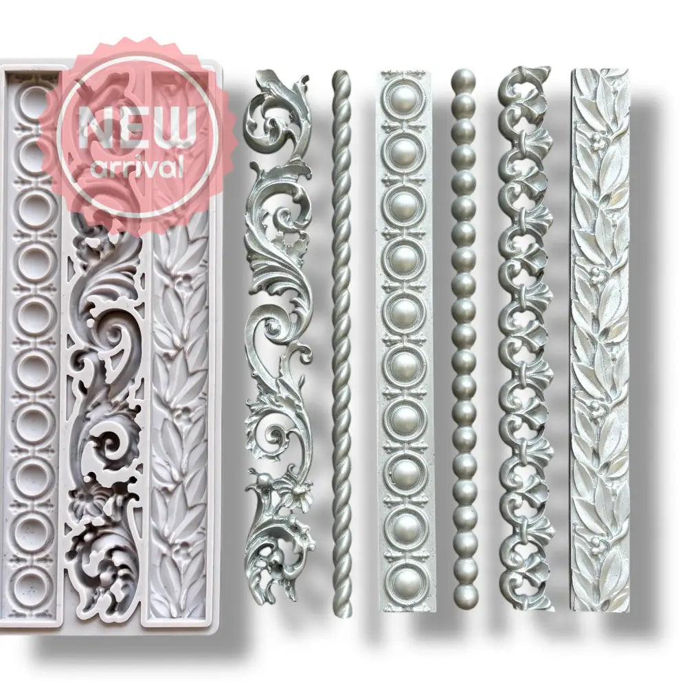 A light grey silicone mold and silver colored castings of 6 intricate border designs are against a white background.