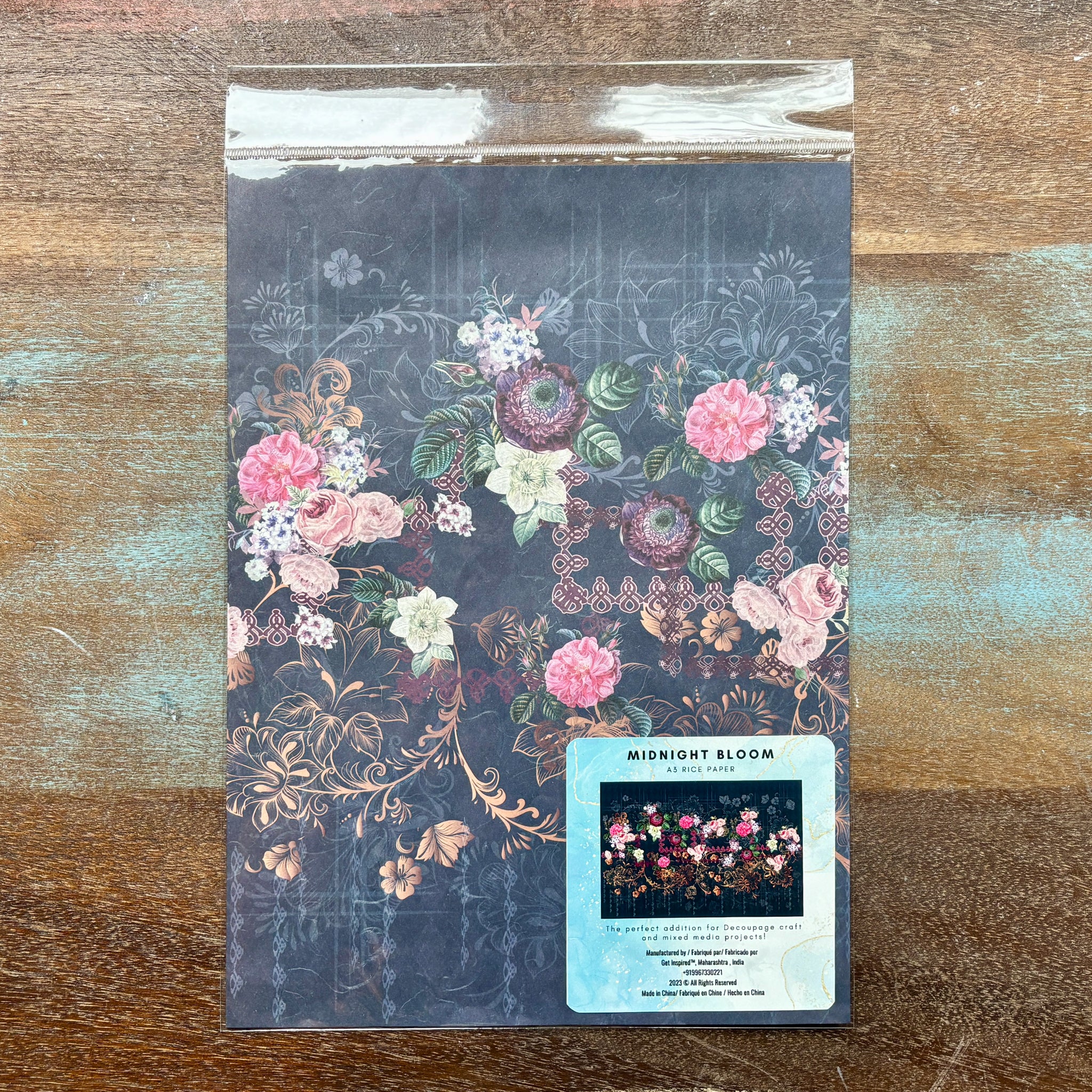 A package of Dadarkar Arts by Get Inspired's Midnight Bloom A3 rice paper is against a wood background.