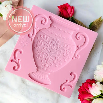 Pink silicone mold with decorative design on a white surface with flowers.