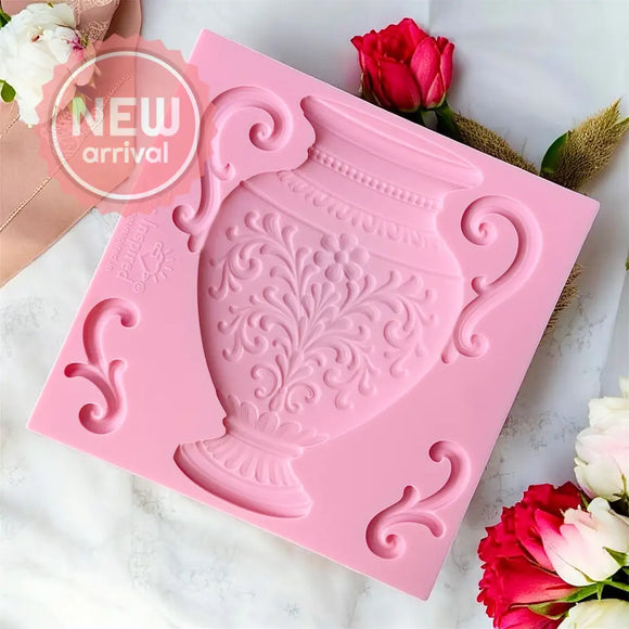 Pink silicone mold with decorative design on a white surface with flowers.