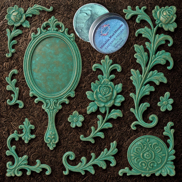 An open container of Dadarkar Art's Emerald Patina Metallic Wax Mousse is amongst resin silicone mold castings of a vintage hand mirror and various corner and accent rose flourishes.