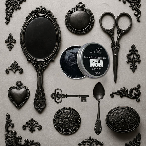 An open container of Dadarkar Art's Rich Black Metallic Wax Mousse is amongst resin silicone mold castings of vintage items including a hand mirror, scissors, a spoon, a key, and various corner and accent flourishes.