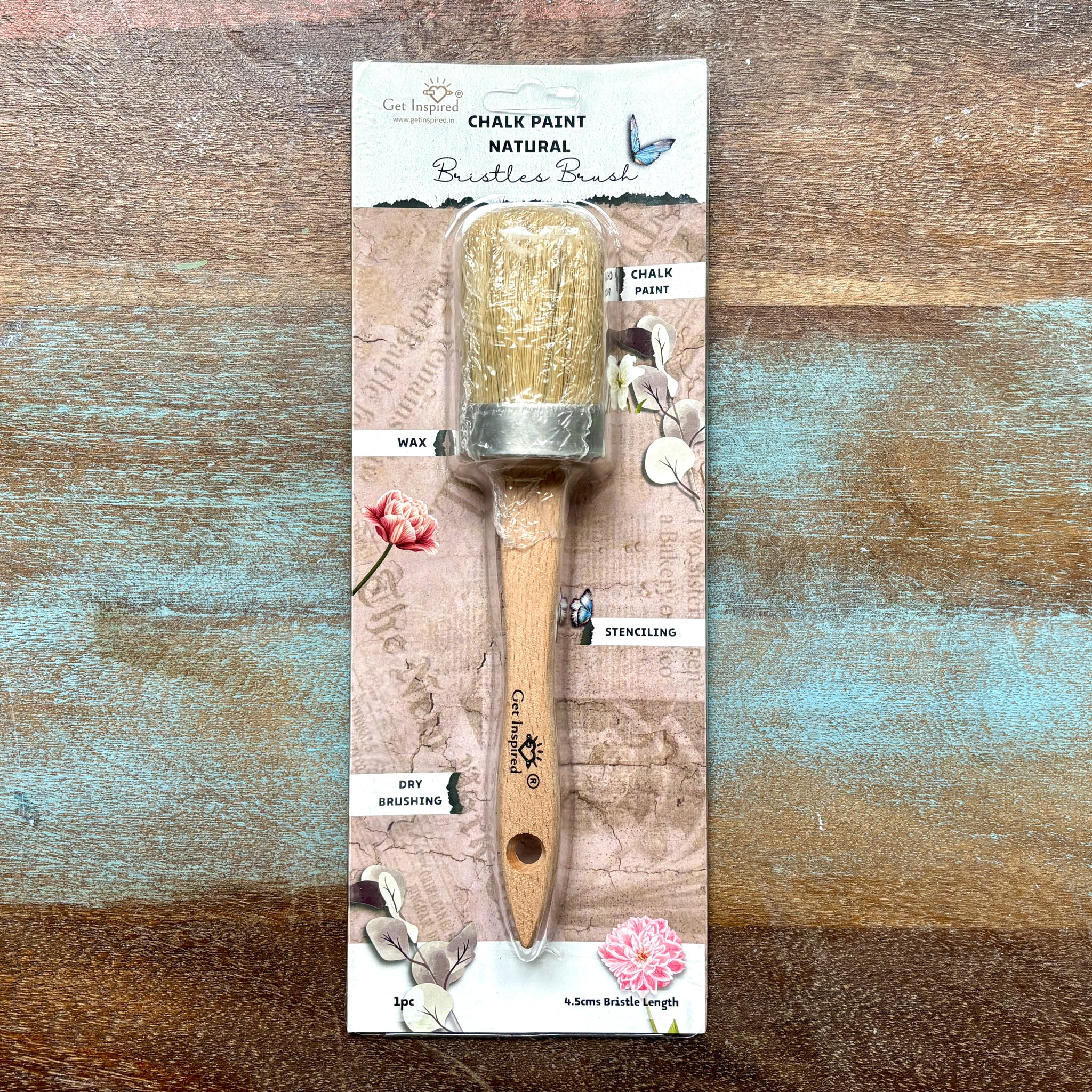 A package of Dadarkar Arts by Get Inspired's Oval Paint Brush for chalk paint, wax, stenciling, and dry brushing is against a wood background.