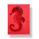 A red silicone mold featuring a seahorse is against a white background.