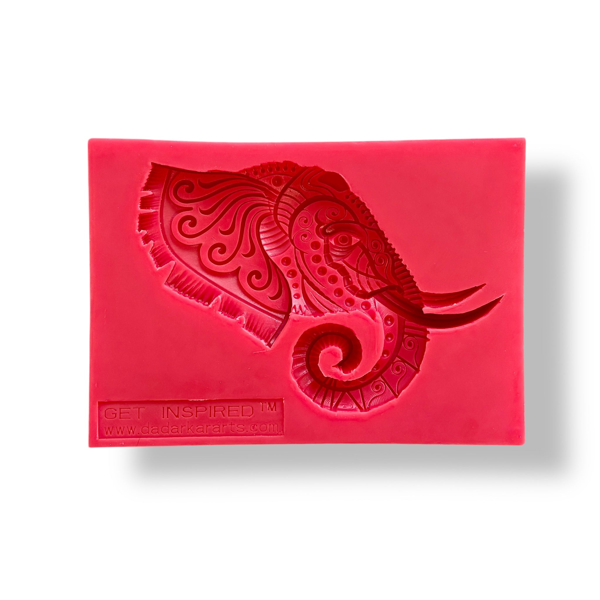 A red silicone mold featuring an elephant head with ornate adornments is against a white background.