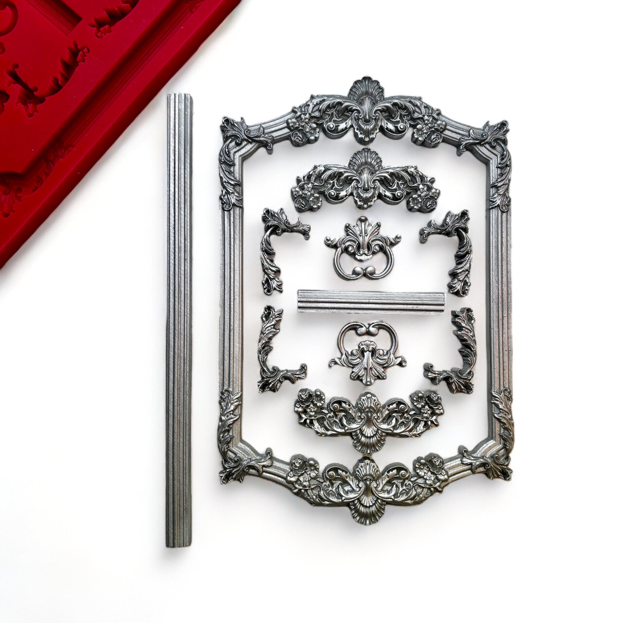 Silver colored castings of ornate vintage frames and borders are against a white background.