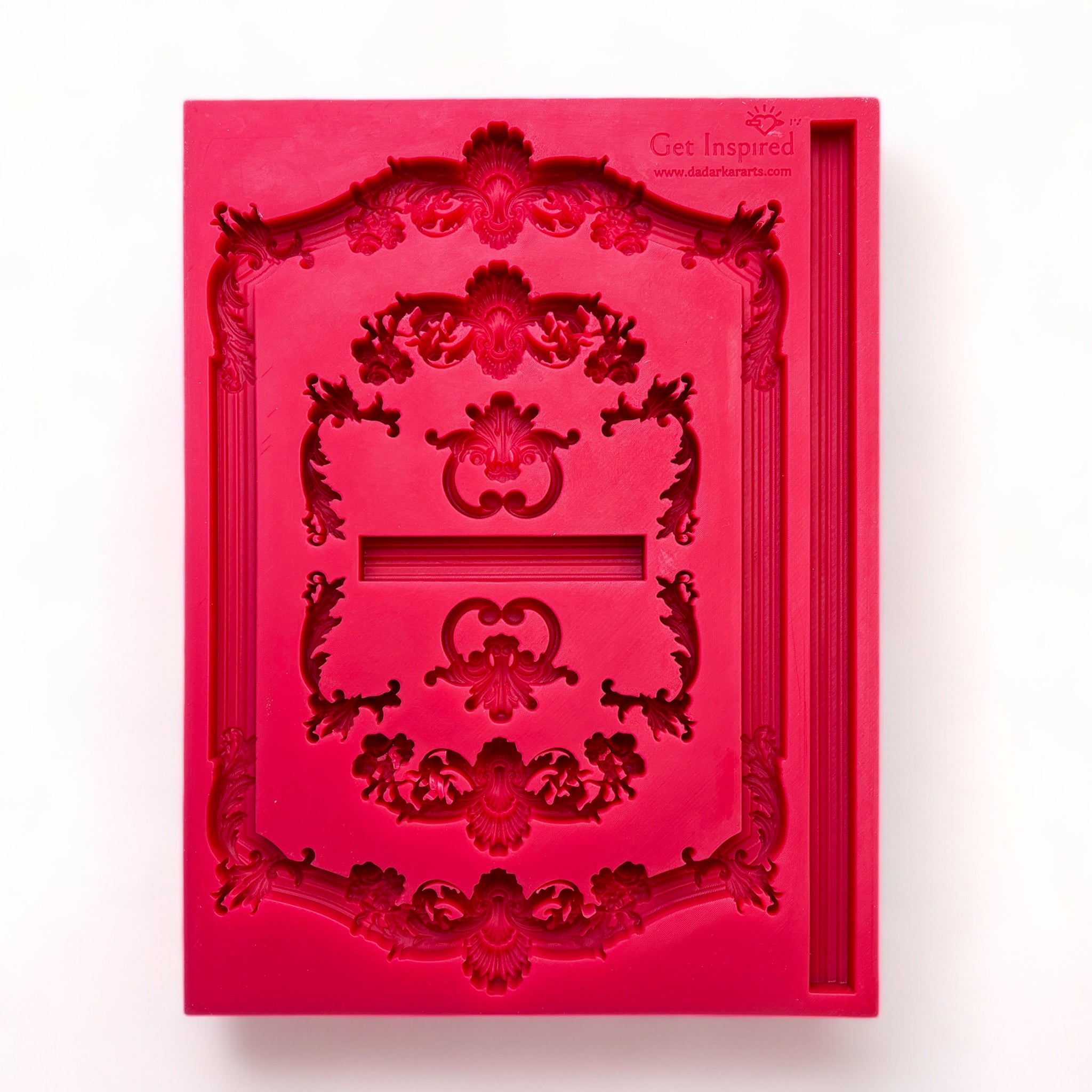 A red silicone mold laying vertically features ornate vintage frames and borders is against a white background.