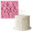 Silicone mold with floral design and a cake decorated with similar design on a white background