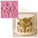 Pink silicone mold with floral design next to a cake decorated with gold floral patterns