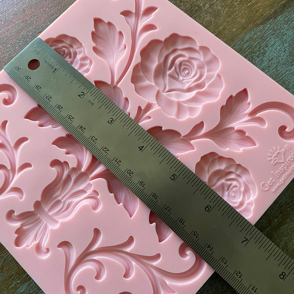Pink floral silicone mold with a ruler for scale on a wooden surface