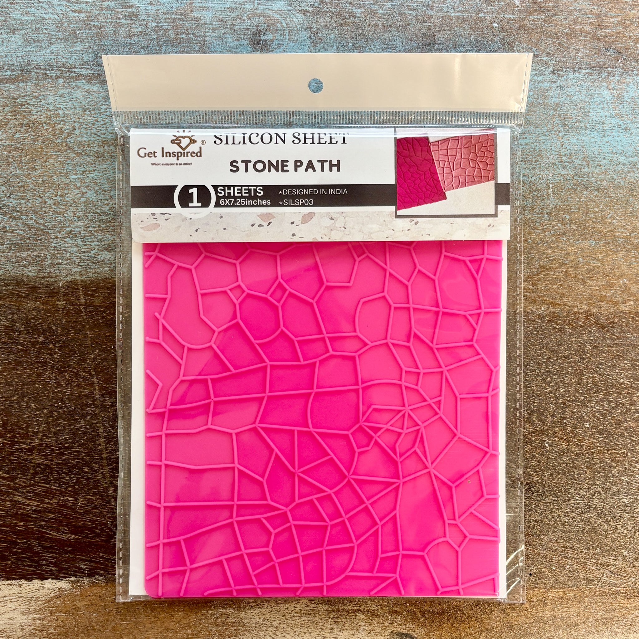 A package of Dadarkar Art by Get Inspired's Stone Path silicone texture sheet is against a wood background.