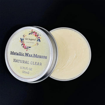 Metallic Wax Mousse container with open lid on a black background