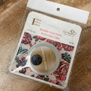 Packaged wax paste with floral design on a wooden surface